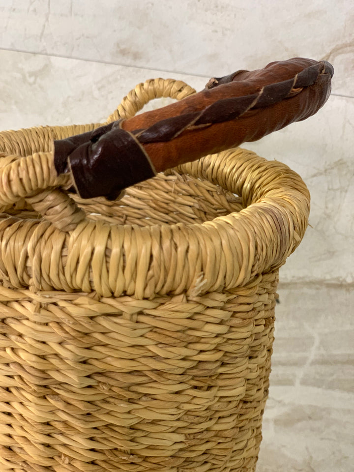 Handwoven straw Astoria vase and wine holder, showing the natural weave and leather handle.