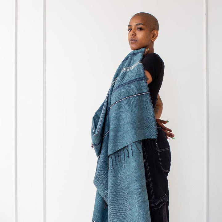 Woman with the steel blue cotton throw draped over her shoulder.